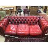 A VINTAGE THREE SEATER CHESTERFIELD IN OXBLOOD RED