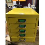 A YELLOW METAL FIVE DRAWER FILING CABINET