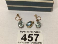 A HALLMARKED 9CT GOLD PENDANT WITH BLUE TOPAZ WITH A FURTHER PAIR OF BLUESTONE EARRINGS WITH