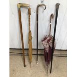 A QUANTITY OF WALKING STICKS AND CANES, UMBRELLAS, SILVER HANDLES AND TIPS