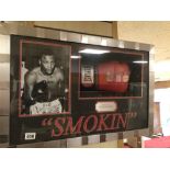 A FRAMED AND GLAZED PROMOTIONAL SIGNED BOXING GLOVE BY (SMOKIN) JOE FRASIER