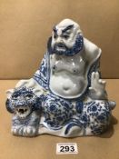 A VINTAGE ORIENTAL BLUE AND WHITE PORCELAIN BUDDHA FIGURE WITH A TIGER 23CM