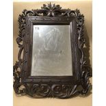 A SMALL WOODEN CARVED WALL MIRROR 58 X 42CM