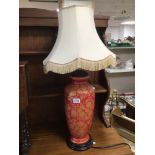 A RED PORCELAIN LAMP WITH GOLD FLORAL DISPLAY 82CM