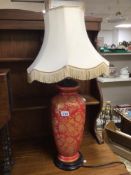 A RED PORCELAIN LAMP WITH GOLD FLORAL DISPLAY 82CM