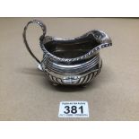 A GEORGE IV REGENCY PERIOD HALLMARKED SILVER HALF FLUTED MILK JUG ON BUN FEET POSSIBLY CHARLES FOX