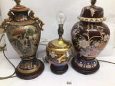 THREE VINTAGE EASTERN TABLE LAMPS DECORATED WITH FIGURES AND FLOWERS WITH WOODEN BASES