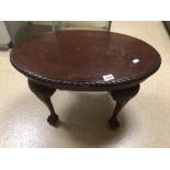 A REPRODUCTION OVAL TABLE ON BALL AND CLAW FEET