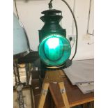 A BRITISH RAIL LAMP CONVERTED ON TO A PAIR OF WOODEN STRETCHERS AS AN ELECTRIC LAMP