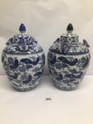 A PAIR OF CHINESE BLUE AND WHITE VINTAGE LIDDED URNS DECORATED WITH FROGS, CHARACTER MARKS TO BASE