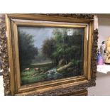 A 19TH CENTURY FRAMED AND GLAZED OIL ON CANVAS COUNTRY SCENE WITH GRAZING CATTLE IN GILDED FRAME