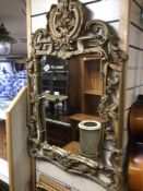 A GILDED ORNATE WALL MIRROR WITH FLORAL DETAILING