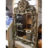 A GILDED ORNATE WALL MIRROR WITH FLORAL DETAILING