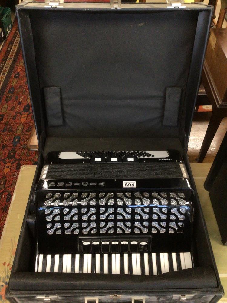 A CASED DELICIA CARMEN 22 ACCORDION IN BLACK AND WHITE