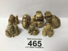 SEVEN CARVED RESIN FIGURES ONE BEING A CAMEL