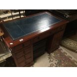A MAHOGANY KNEEHOLE DESK WITH NINE DRAWERS WITH A BLUE LEATHER TOP