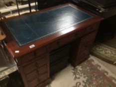 A MAHOGANY KNEEHOLE DESK WITH NINE DRAWERS WITH A BLUE LEATHER TOP