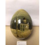 A HAND PAINTED OSTRICH EGG INDISTINCTLY SIGNED TO BASE