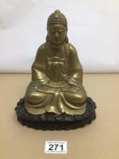 A VINTAGE BRASS BUDDHA ON WOODEN STAND 23CM