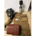 A SMALL COLLECTION OF WWII MEMORABILIA INCLUDES A GAS MASK, A FIRST AID POUCH (WITH CONTENTS), AND A