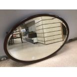 A VINTAGE MAHOGANY FRAMED BEVELLED GLASS OVAL WALL MIRROR, 79 X 55CM