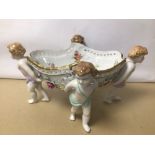 A PORCELAIN CENTREPIECE WITH CHERUBS / PUTTI ANGELS DECORATED IN FLOWERS, STAMPED ‘M’ TO BASE,