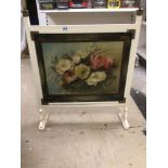 A VINTAGE FIRE SCREEN WITH A PAINTING OF A FLORAL SCENE TO FRONT