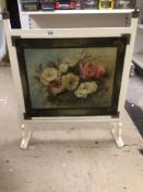 A VINTAGE FIRE SCREEN WITH A PAINTING OF A FLORAL SCENE TO FRONT