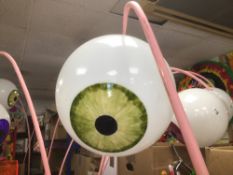 A PERSPEX EYEBALL ON A PIN METAL STAND