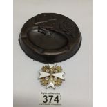 A VINTAGE COPPER ASHTRAY WITH AN EMBOSSED SOLDIER WITH A GERMAN ENAMEL BADGE