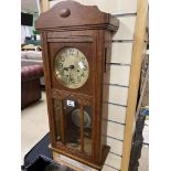 A VINTAGE OAK CASED WALL CLOCK WITH PENDULUM AND KEYS