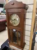 A VINTAGE OAK CASED WALL CLOCK WITH PENDULUM AND KEYS