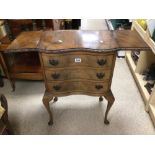 A VINTAGE CAMEO FURNITURE SERPENTINE FRONTED THREE DRAWER CHEST WITH EXTENDING LEAVES TO THE