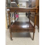 A VINTAGE TWO TIER TABLE ON ORIGINAL BRASS CASTORS