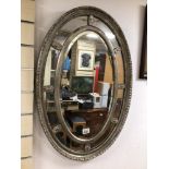 A VINTAGE SILVERED OVAL BEVELLED MIRROR, 78 X 53CM