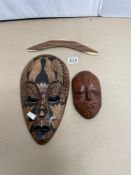 TWO WOODEN TRIBAL WALL MASKS KORURU (NEW ZEALAND) AND ONE OTHER, ALSO A BOOMARANG