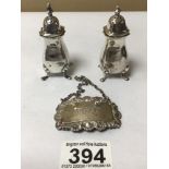 A PAIR OF HALLMARKED SILVER PEPPERPOTS ON PAD FEET & HALLMARKED SILVER SPIRIT LABEL, 75G