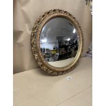 AN OVAL CONVEX MIRROR WITH GILDED BORDERS 50CM IN DIAMETER