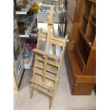 AN UNUSUAL WOODEN FOLDING EASEL WITH SHELVES