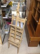 AN UNUSUAL WOODEN FOLDING EASEL WITH SHELVES