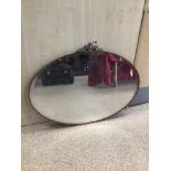 A VINTAGE OVAL BEVELLED MIRROR WITH A METAL SURROUND, 74 X 54CM