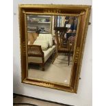 AN ORNATE BEVELLED EDGED GILDED MIRROR, 86 X 67CM