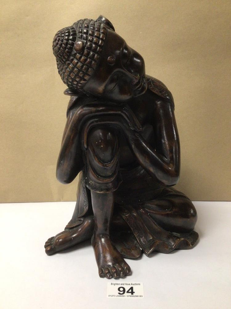 A LARGE FINISHED RESIN (TO GIVE A WOOD EFFECT) SEATED THAI BUDDHA, HEAD ON KNEE, 28CM IN HEIGHT