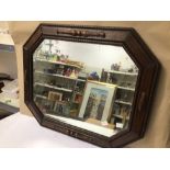 AN EARLY 20TH CENTURY ARTS N’ CRAFTS BEVELLED EDGE WALL MIRROR IN OCTAGONAL FORM, WITH A