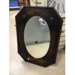 AN EARLY 20TH CENTURY ARTS N’ CRAFTS BEVELLED EDGE WALL MIRROR IN OVAL FORM, WITH A DECORATIVE