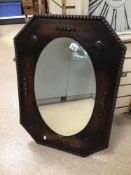 AN EARLY 20TH CENTURY ARTS N’ CRAFTS BEVELLED EDGE WALL MIRROR IN OVAL FORM, WITH A DECORATIVE