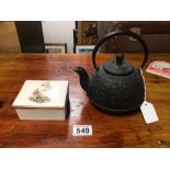 A CAST IRON CHINESE TEA POT WITH A CERAMIC ASHTRAY