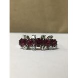 750 WHITE GOLD RING WITH EIGHT DIAMONDS SURROUNDING FIVE GARNETS, SIZE Q