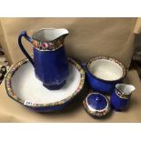 FIVE SIMILAR POTTERY BOWLS/VASES AND A JUG, ALL IN BLUE WITH FRUIT/VEGETABLE DESIGN ON RIMS, ONE