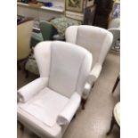 A PAIR OF CREAM UPHOLSTERED WINGBACK CHAIRS